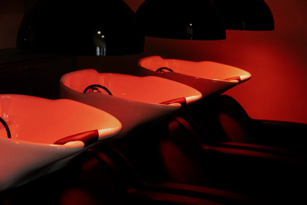 Lavatesta del salone di parrucchieri in un ambiente con luce rossa soffusa