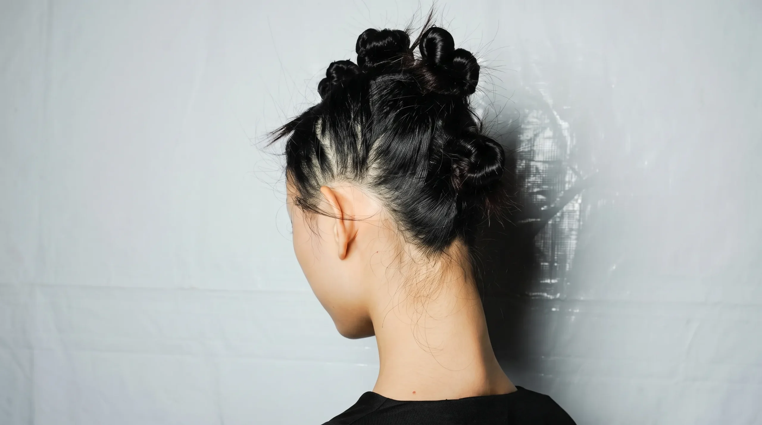 Donna di spalle con capelli raccolti in piccoli chignon