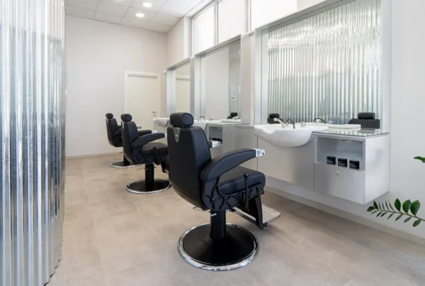 Postazioni di lavoro del salone Gianluca Spagnolo Hairlab con poltrone nere e specchi