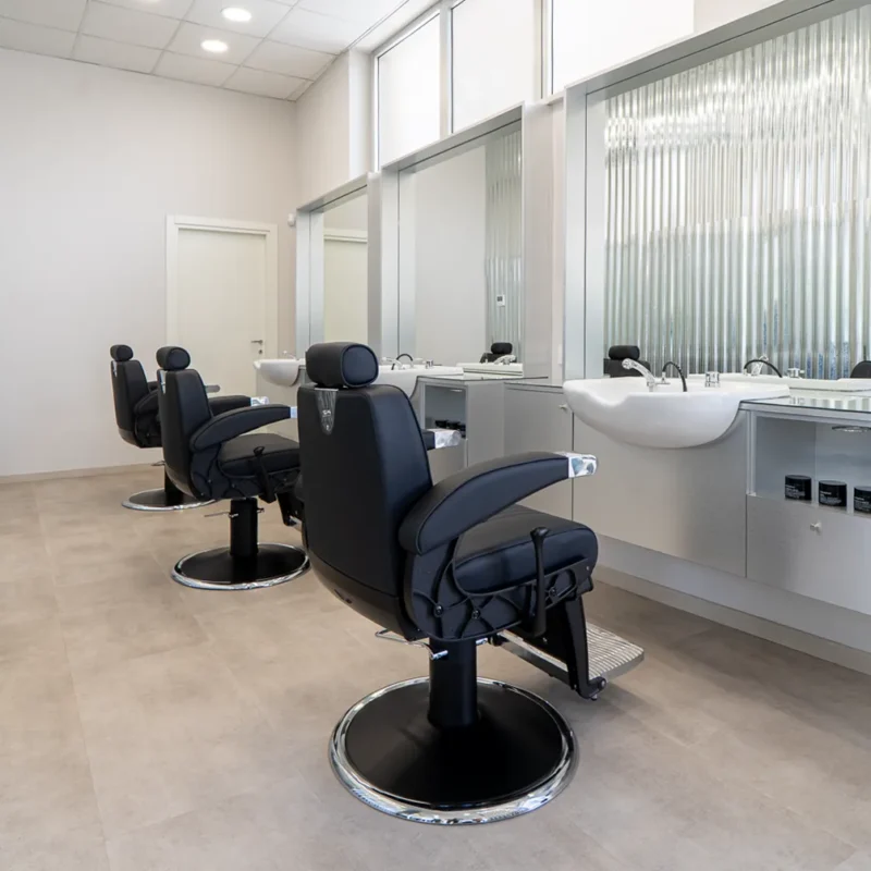 Postazioni di lavoro del salone Gianluca Spagnolo Hairlab con poltrone nere e specchi