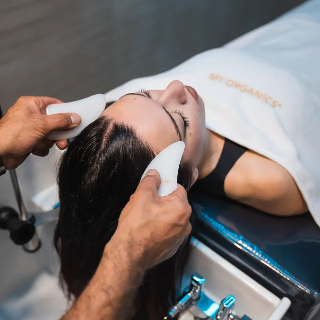 Massaggio del cuoio capelluto con strumenti da massaggio durante un trattamento Hair Spa
