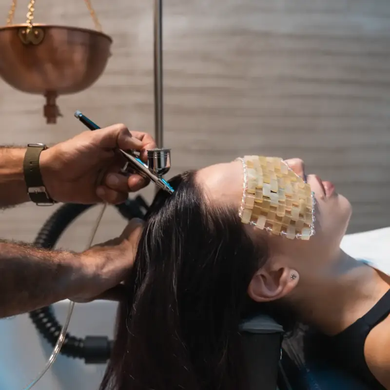 Trattamento Hair Spa al lavatesta: nebulizzazione sul cuoio capelluto con la cliente distesa e una maschera sugli occhi