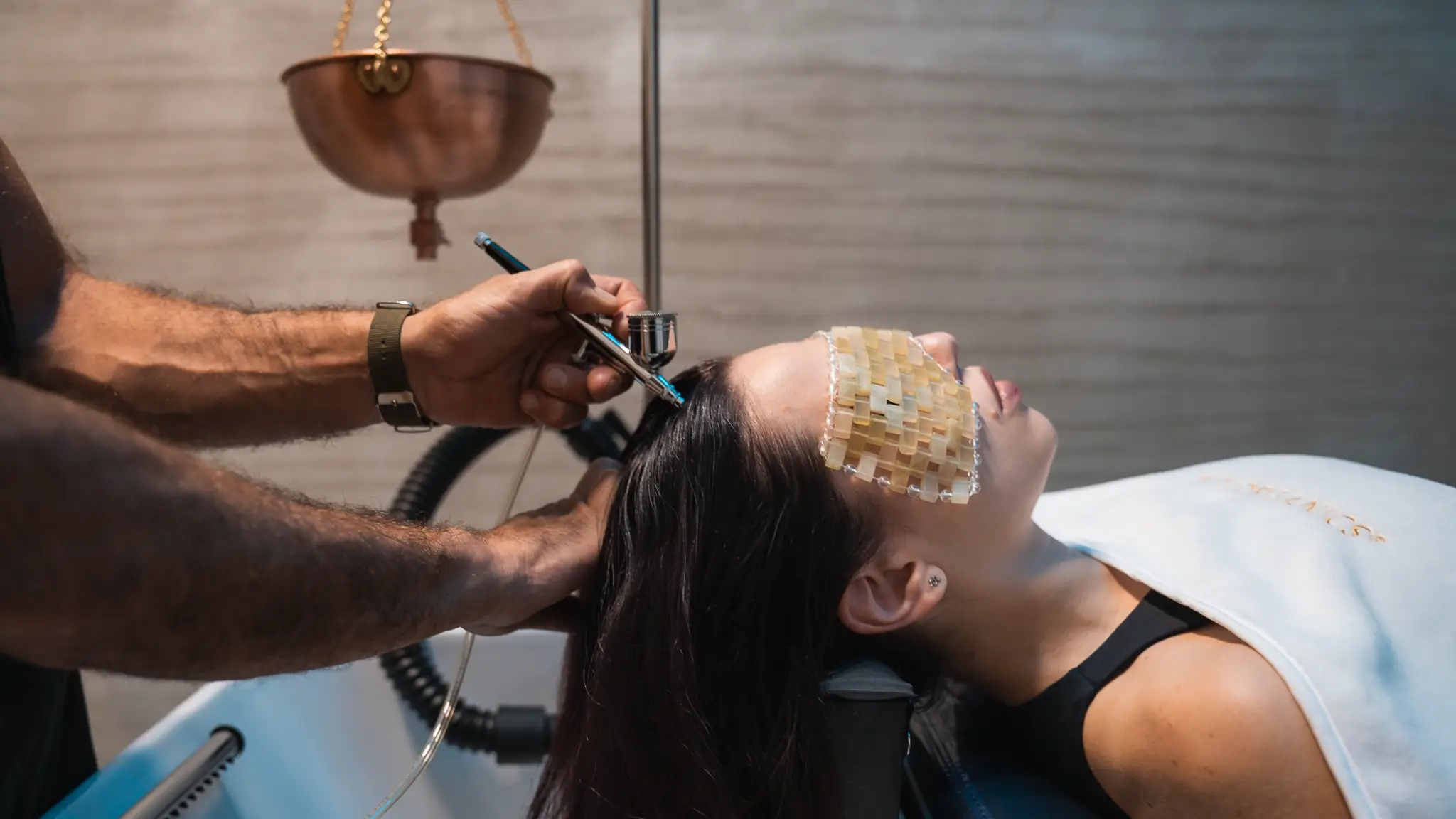 Trattamento Hair Spa al lavatesta: nebulizzazione sul cuoio capelluto con la cliente distesa e una maschera sugli occhi