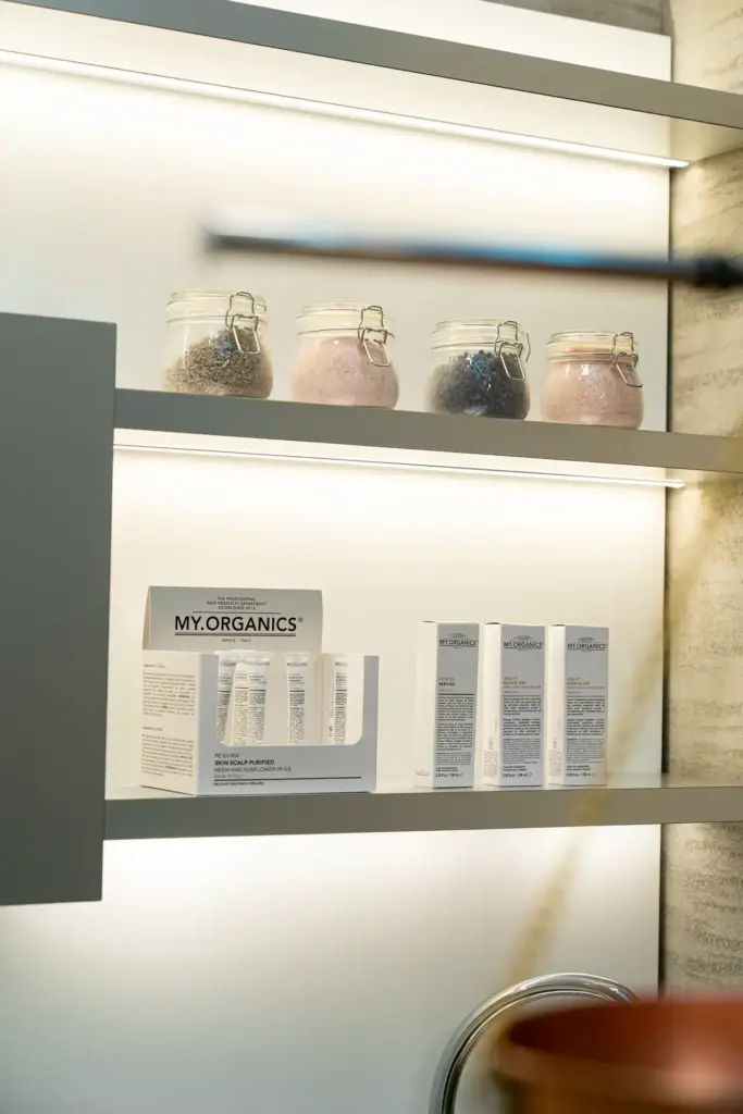 Prodotti My.Organics consigliati dopo la consulenza tricologica, su una mensola con barattoli di sali colorati