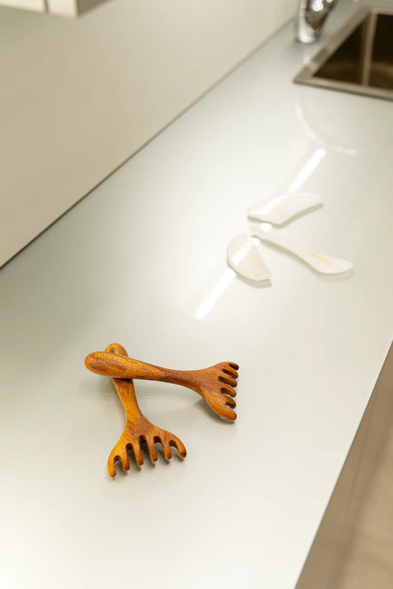 Pettini da massaggio in legno e pietre gua sha bianche su un piano di lavoro